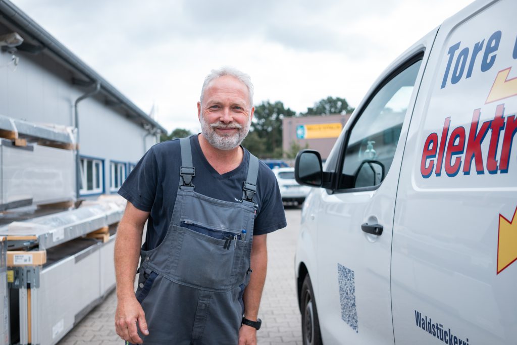 Mitarbeiter neben Firmenbus